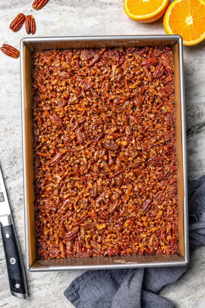 These Pecan Pie Bars have a caramel filling, buttery shortbread crust and NO corn syrup! Honey and brown sugar adds the perfect sweetness. Pan of pecan pie bars.