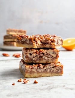 Stack of 3 pecan pie bars with bite taken out of top bar.