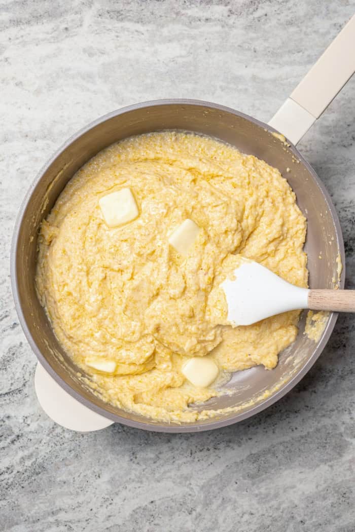 Stirring butter into cornmeal mixture in skillet.