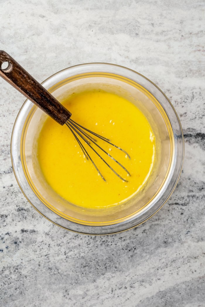 Whisking egg yolks and cornbread mixture in bowl.