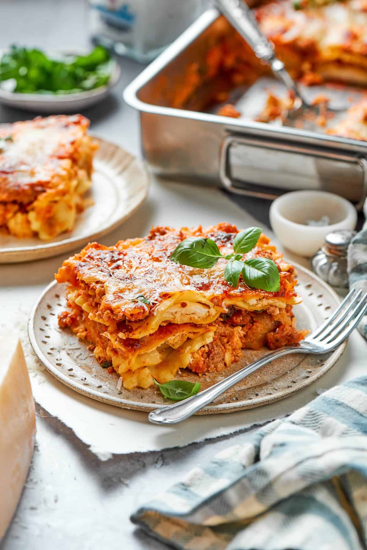 Slice of ravioli lasagna on plate with fork.