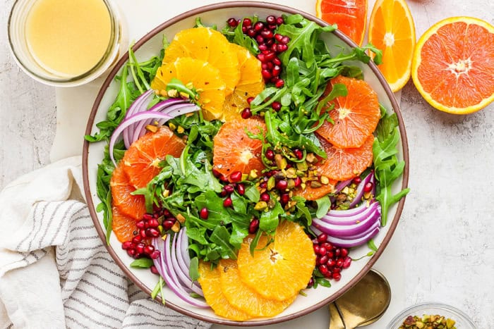 overhead photo of a winter salad with fresh citrus slices and pomegranate arils