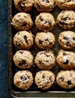 overhead photo of scoops of peanut butter chocolate chip cookie dough on a rimmed sheet pan