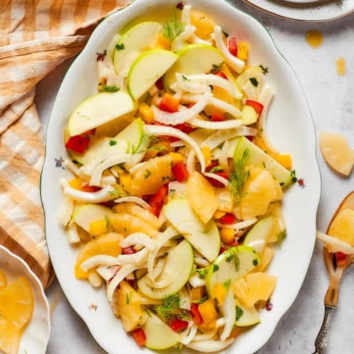 overhead photo of a white platter with fennel, apple, and pineapple salad