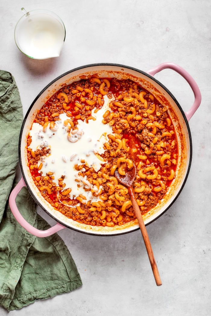 Heavy cream added to skillet for hamburger helper.