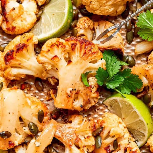 close-up photo of roasted cauliflower on a pan, showing its caramelized edges