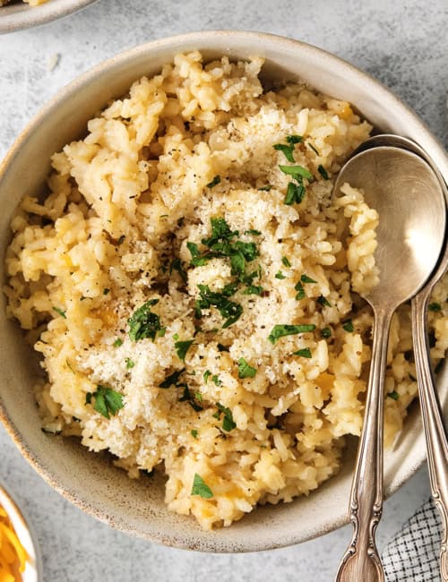 Bowl of cheesy rice with two spoons.