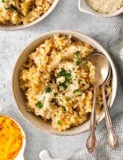 Bowl of cheesy rice with two spoons.