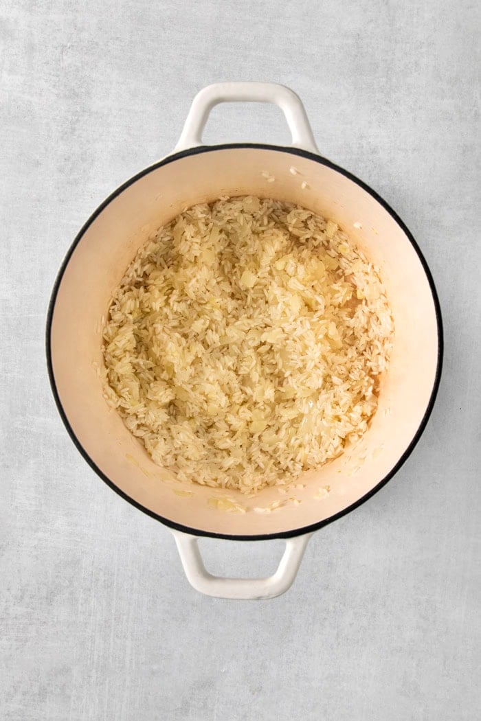This creamy cheesy rice is made with cheddar and Parmesan for double the cheesy goodness. An easy side dish that pairs with any meal! Long grain white rice in pot before cooking.
