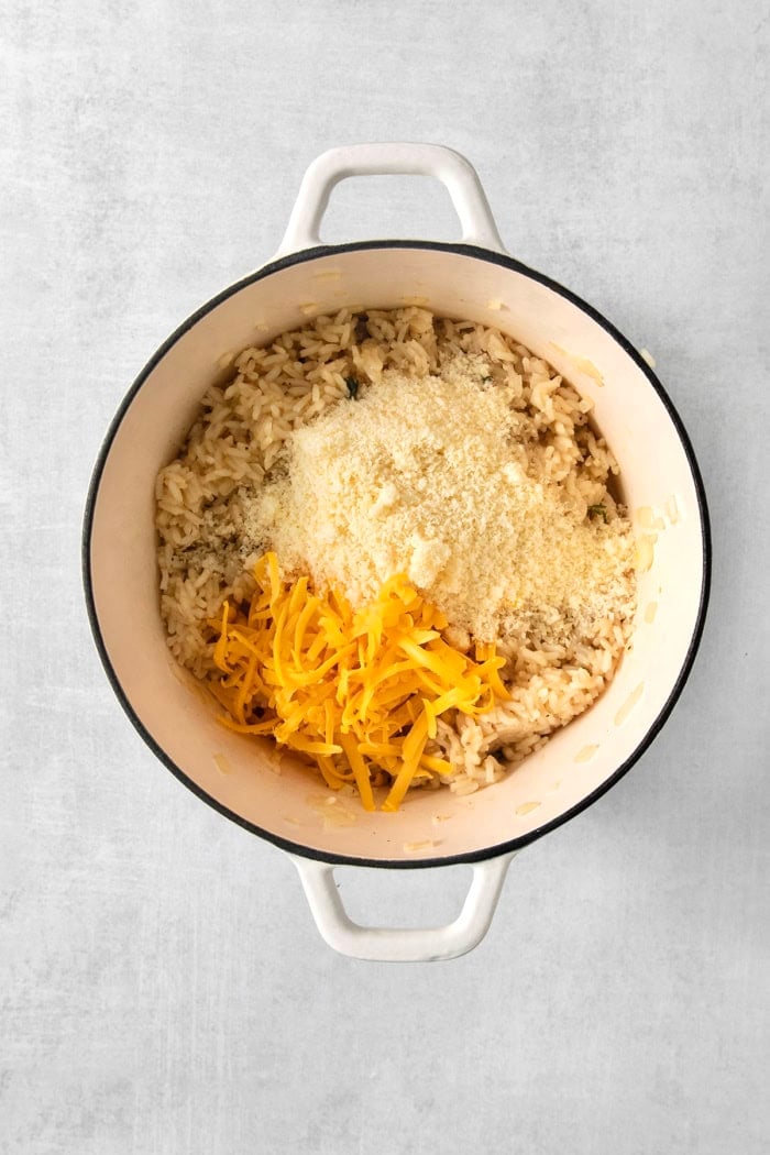 This creamy cheesy rice is made with cheddar and Parmesan for double the cheesy goodness. An easy side dish that pairs with any meal! Parmesan and cheddar cheese added to pot.