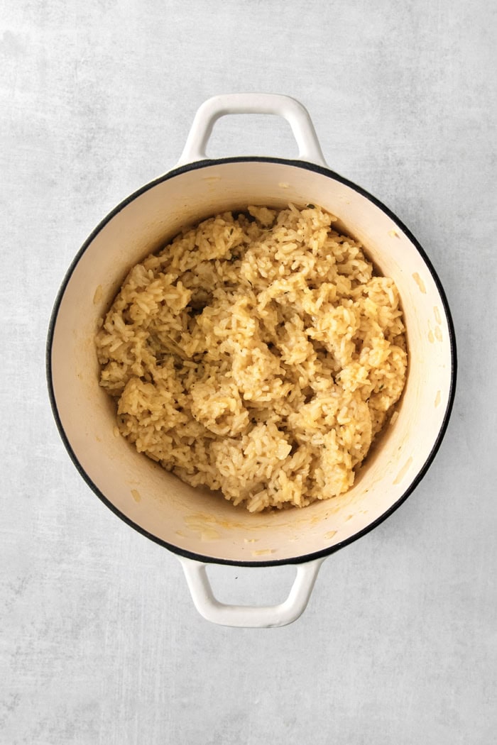 This creamy cheesy rice is made with cheddar and Parmesan for double the cheesy goodness. An easy side dish that pairs with any meal! Cheesy rice in pot.