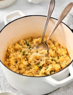 Pot of cheesy rice with two spoons.