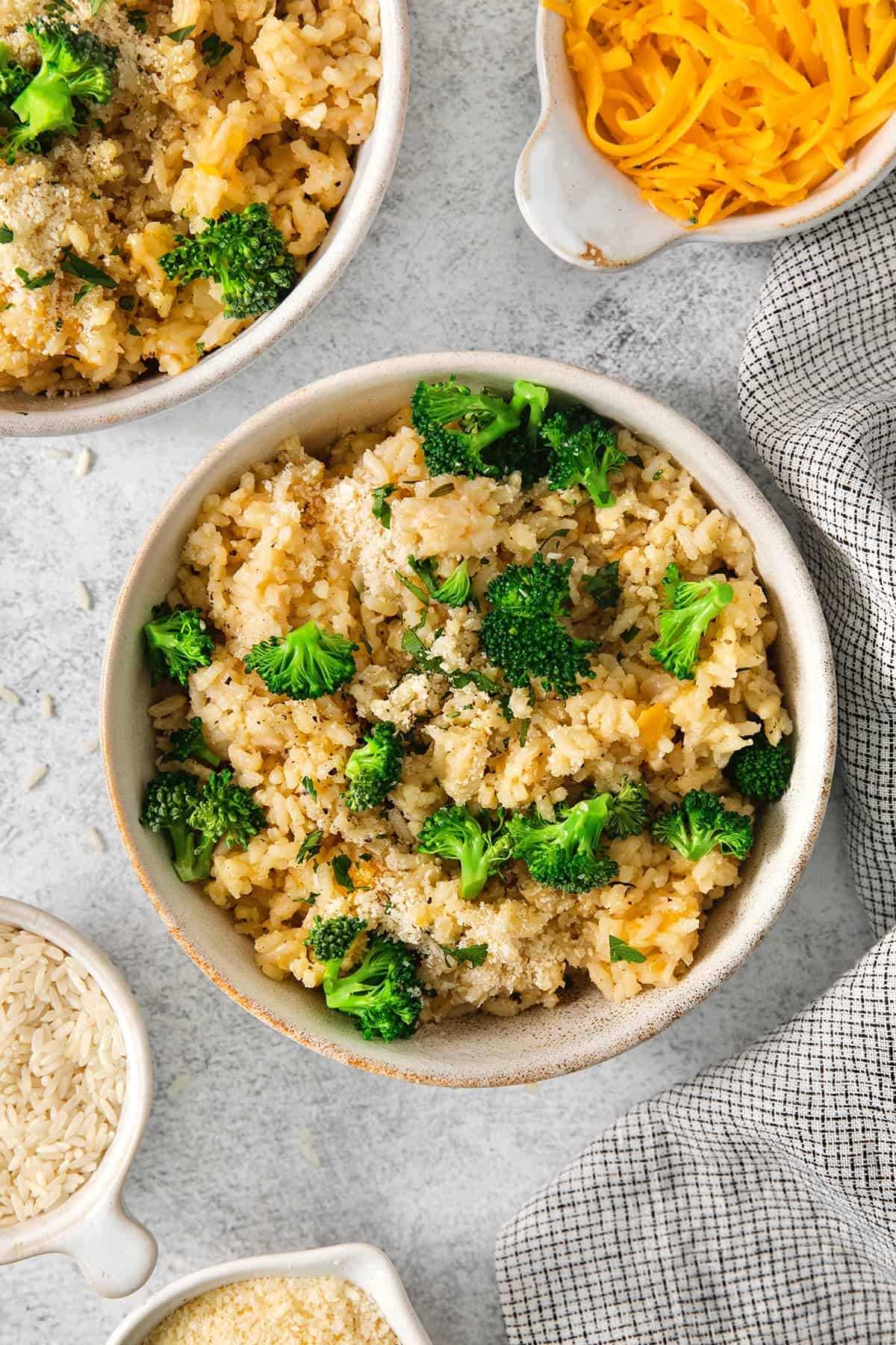 This creamy cheesy rice is made with cheddar and Parmesan for double the cheesy goodness. An easy side dish that pairs with any meal! Bowl of cheesy rice and broccoli.