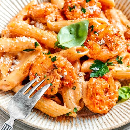 an individual serving of Cajun shrimp pasta on an earth-toned plate