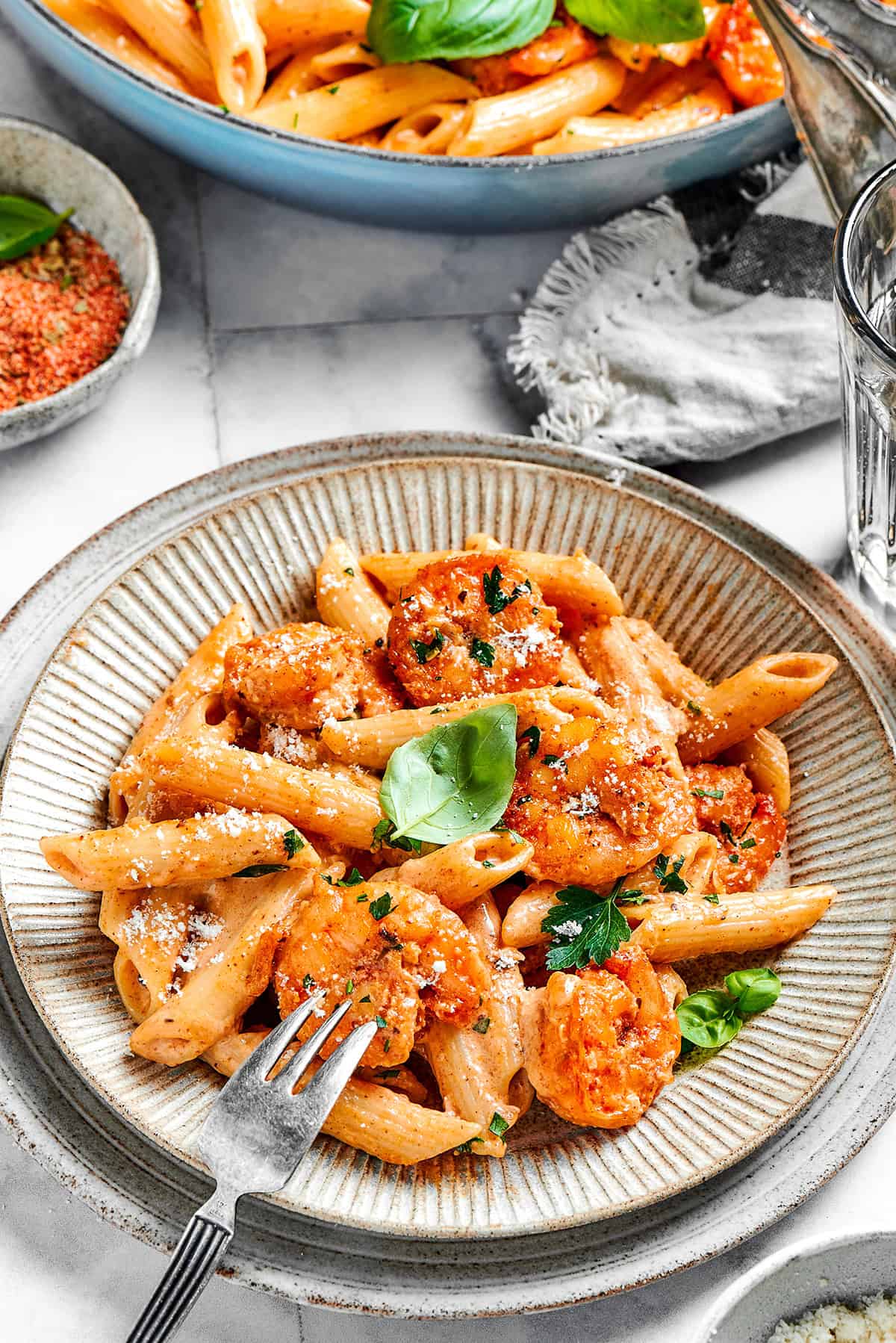 an individual serving of Cajun shrimp pasta on an earth-toned plate