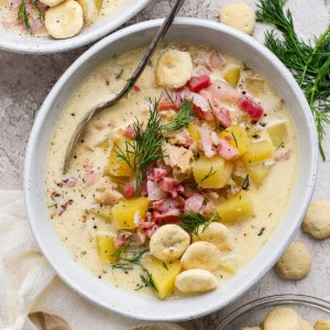 overhead photo of clam chowder with pork belly in a white bowl