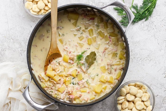 overhead photo of a large pot of clam chowder with pork belly and potatoes