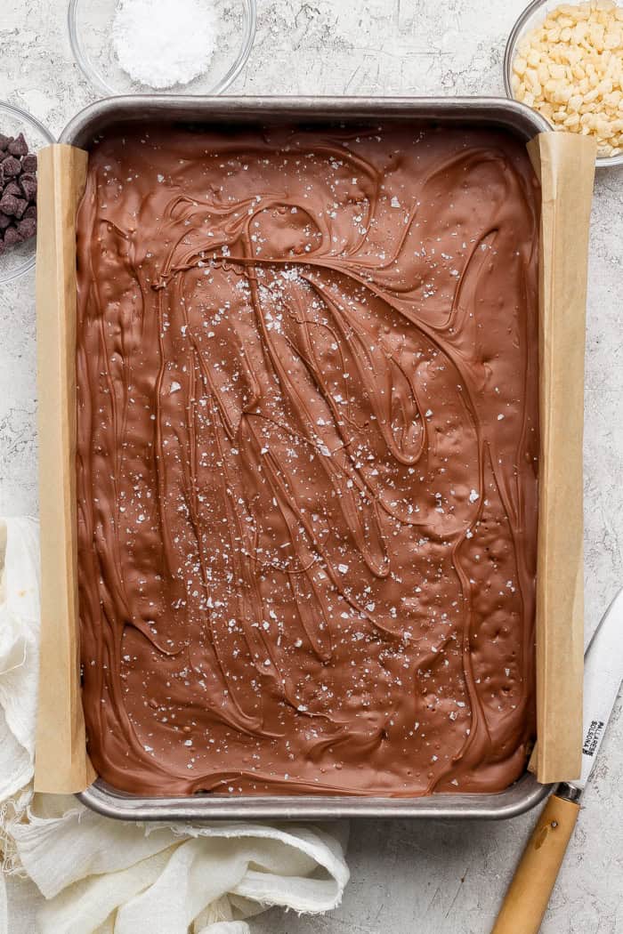 These scotcheroos are chewy, chocolatey, and peanut buttery, with a little sea salt to take them up a notch. An easy no-bake dessert recipe! Dish of scotcheroos topped with sea salt.