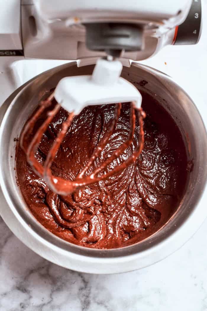 mixing chocolate cake batter in the bowl of a stand mixer