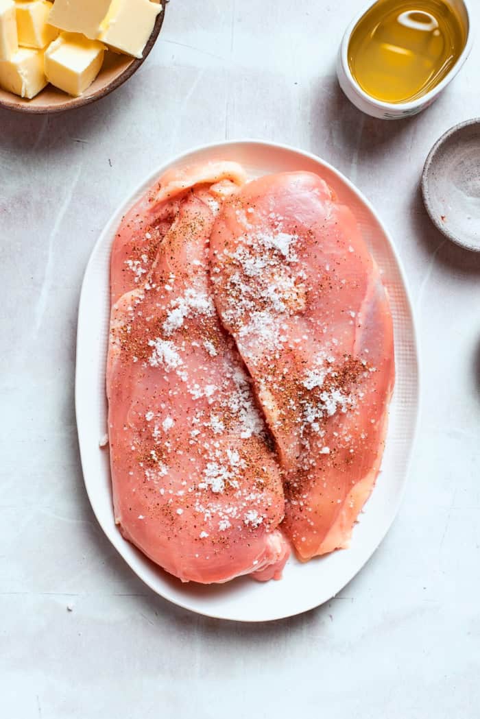 Seasoned chicken breasts on plate.