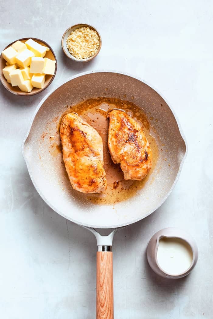 Chicken breasts pan-fried in skillet.