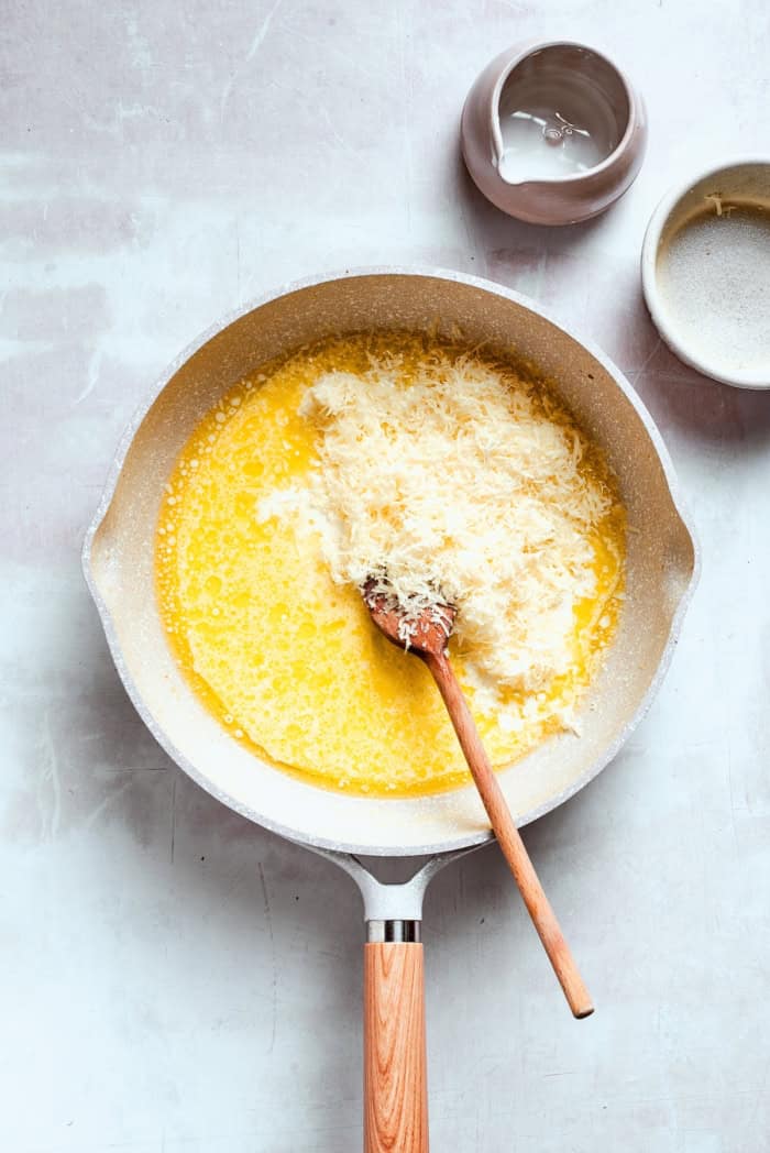 Stirring Parmesan into skillet of melted butter.