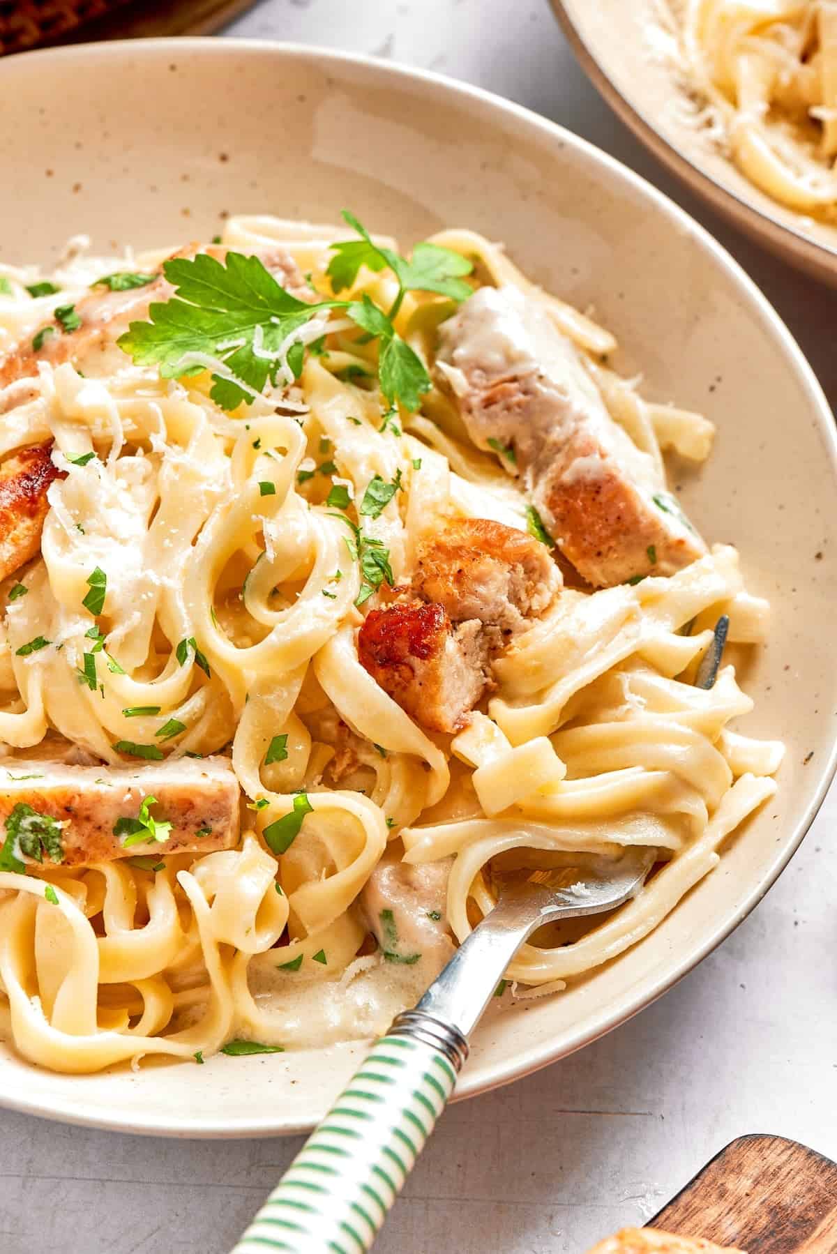 Bowl of chicken fettuccine alfredo with fork.