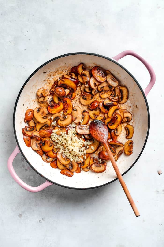 Garlic added to pan of browned mushrooms.