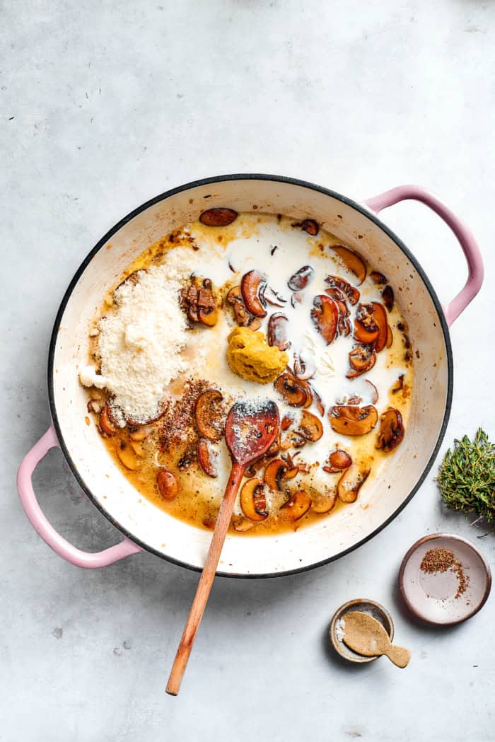 Stirring cream and Parmesan into mushroom sauce.