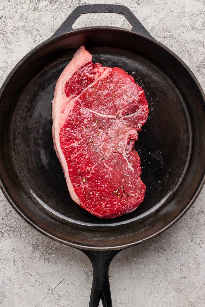 Steak in cast iron skillet.