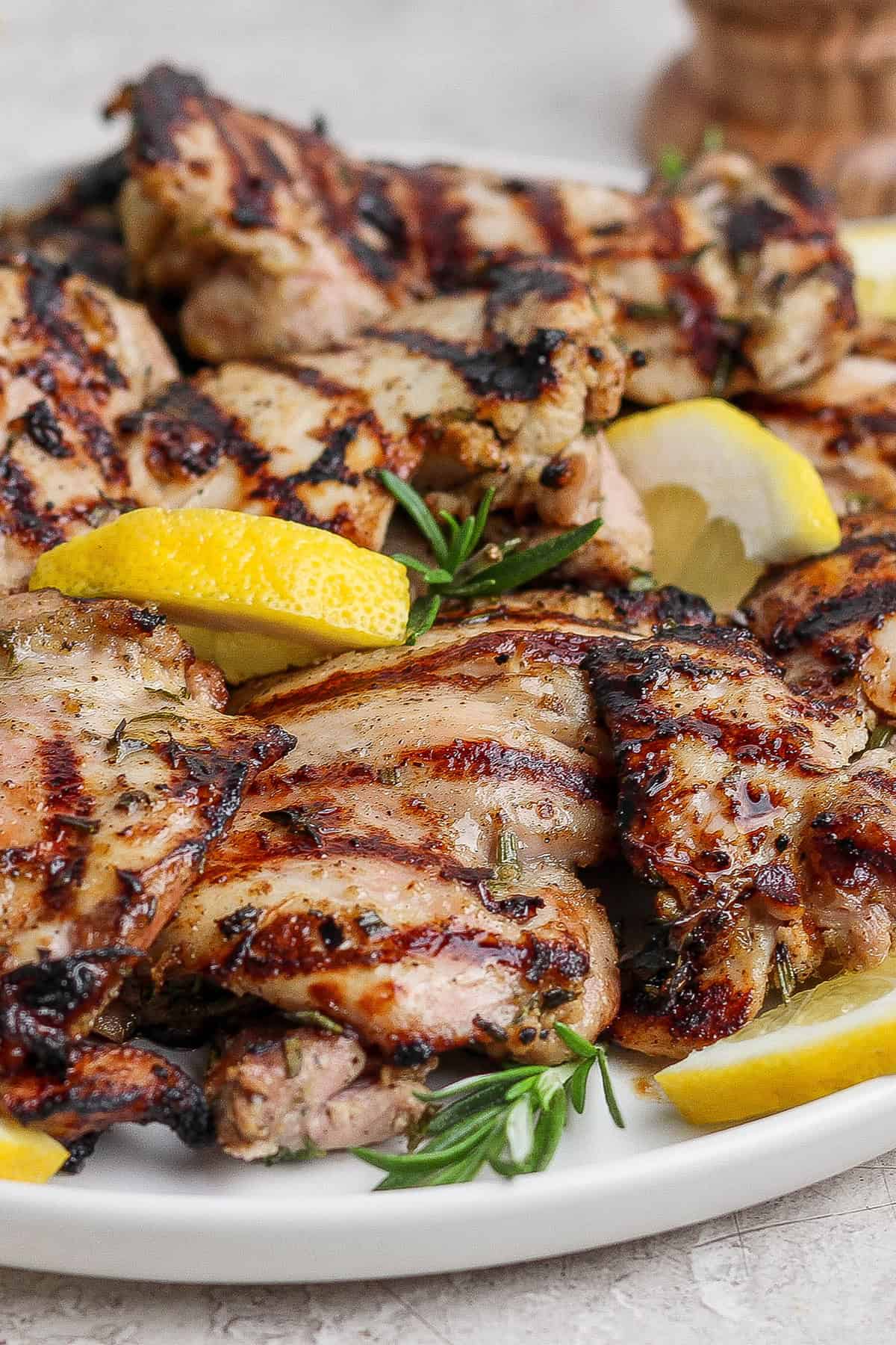 Grilled lemon chicken thighs on plate.