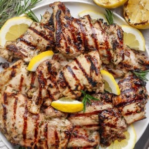 Grilled lemon chicken thighs on platter.