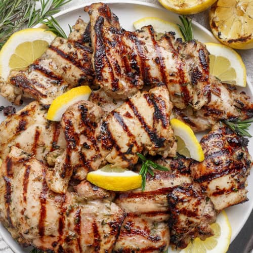 Grilled lemon chicken thighs on platter.