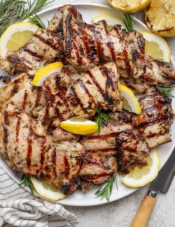 Grilled lemon chicken thighs on platter.