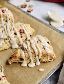 baked rhubarb scones with glaze, on a baking sheet with parchment paper