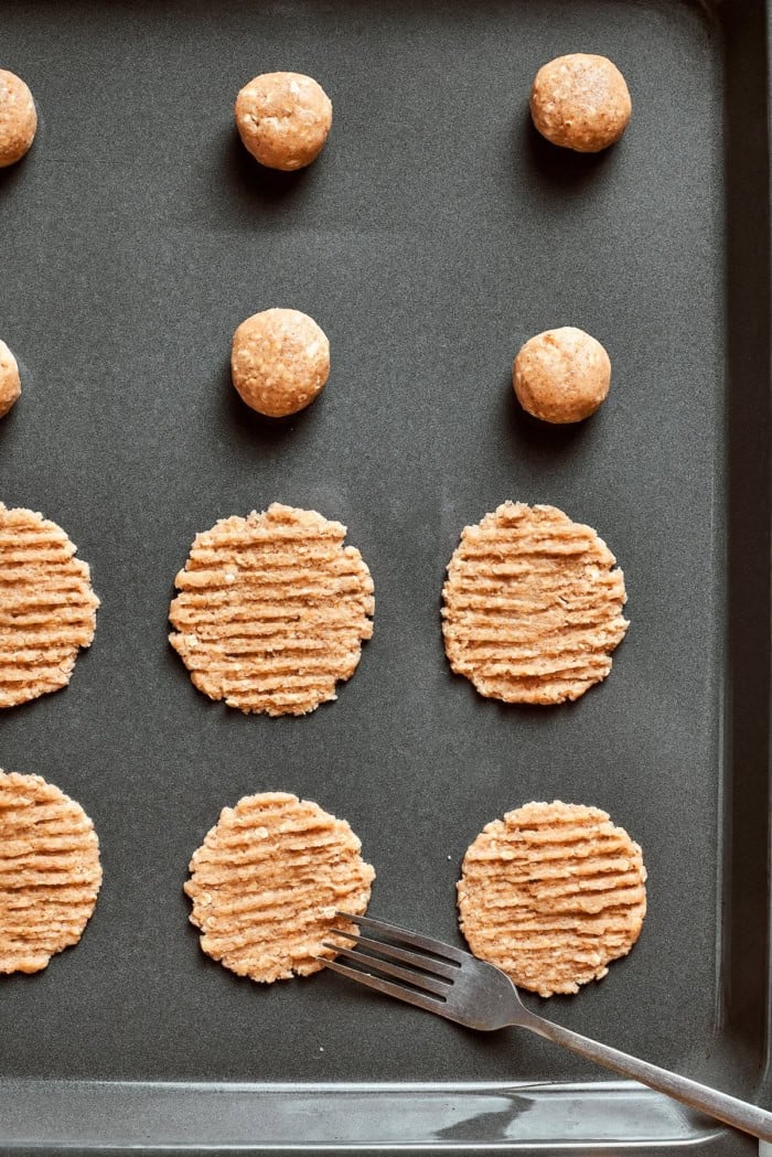 Fork set next to unbaked cookies on pan.