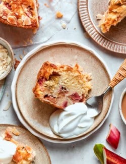 Slice of Norwegian rhubarb cake with whipped cream.