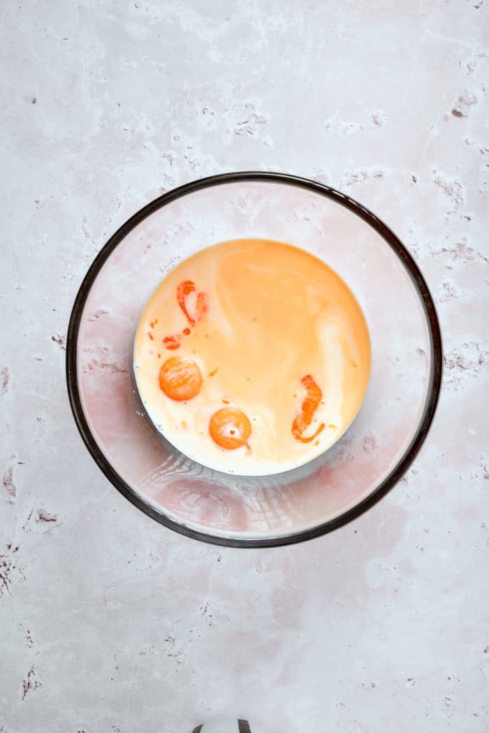 This homemade rhubarb ice cream is ultra creamy, with tart rhubarb flavor and a lovely blush-pink color. Such a fun summer dessert! Custard mixture in bowl.