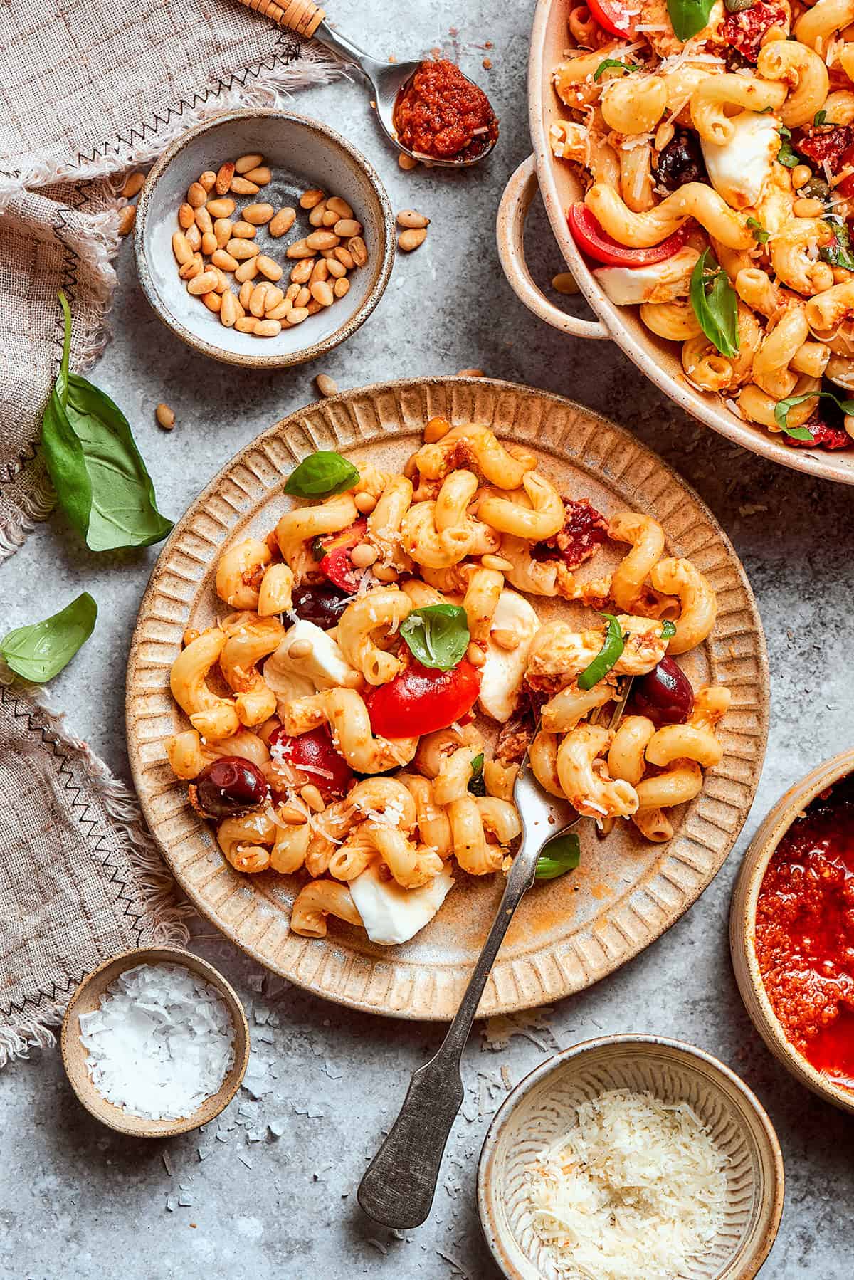 This sun-dried tomato pasta salad lets the abundance of summer produce shine, with juicy tomatoes and fresh basil. Perfect for picnics! an individual plate of pasta salad with sun dried tomatoes