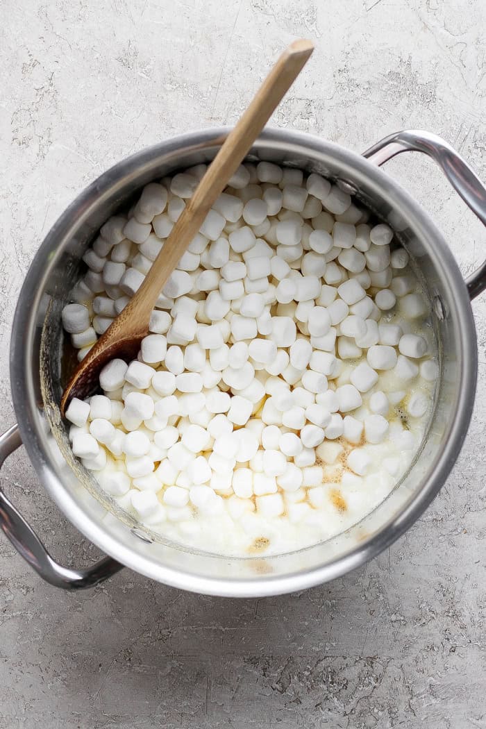 Brown butter Rice Krispie treats are a more indulgent version of the classic, with extra marshmallows, nutty brown butter and flaky sea salt! Marsmallows in pot with wooden spoon.