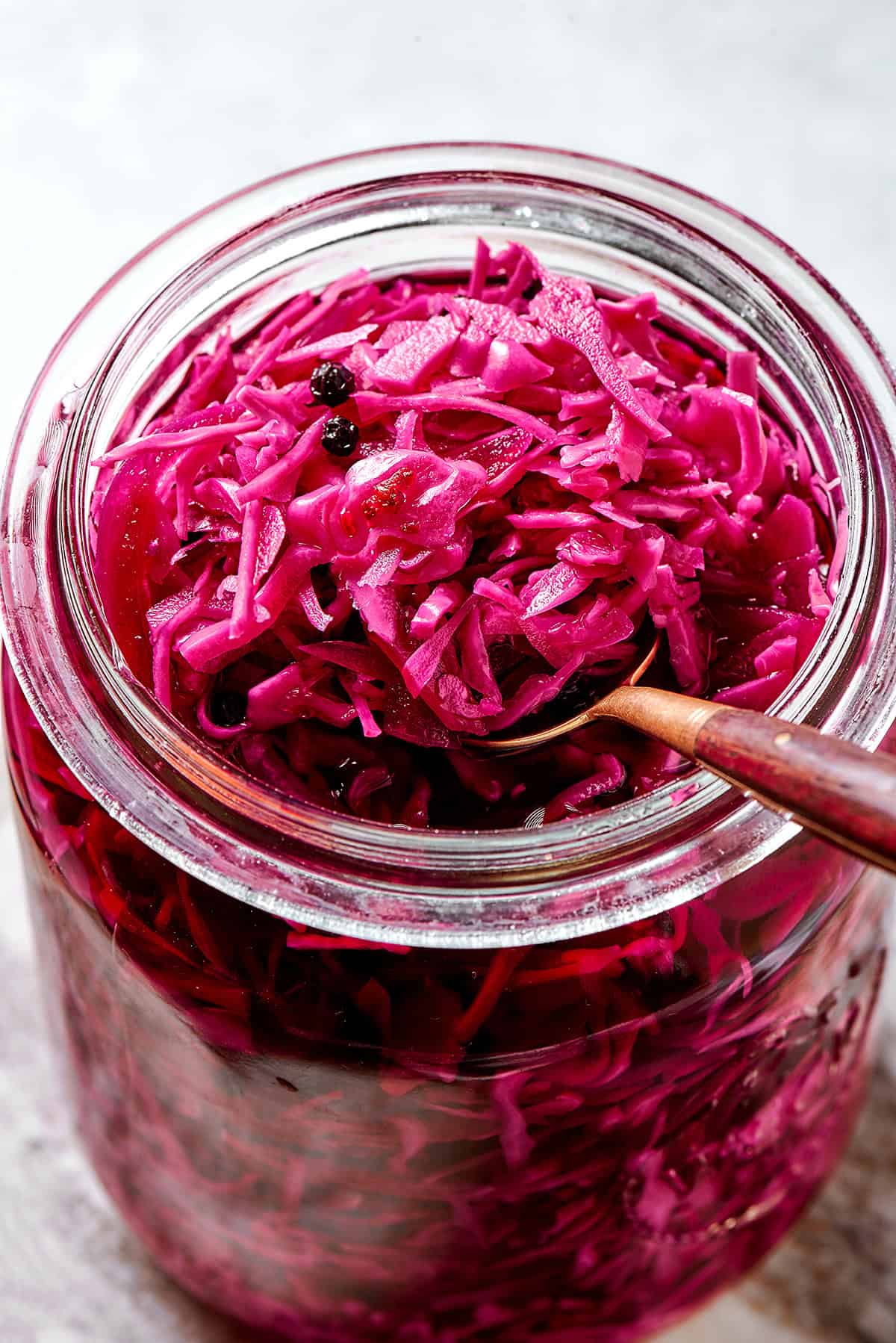 a spoon in a jar of pickled red cabbage
