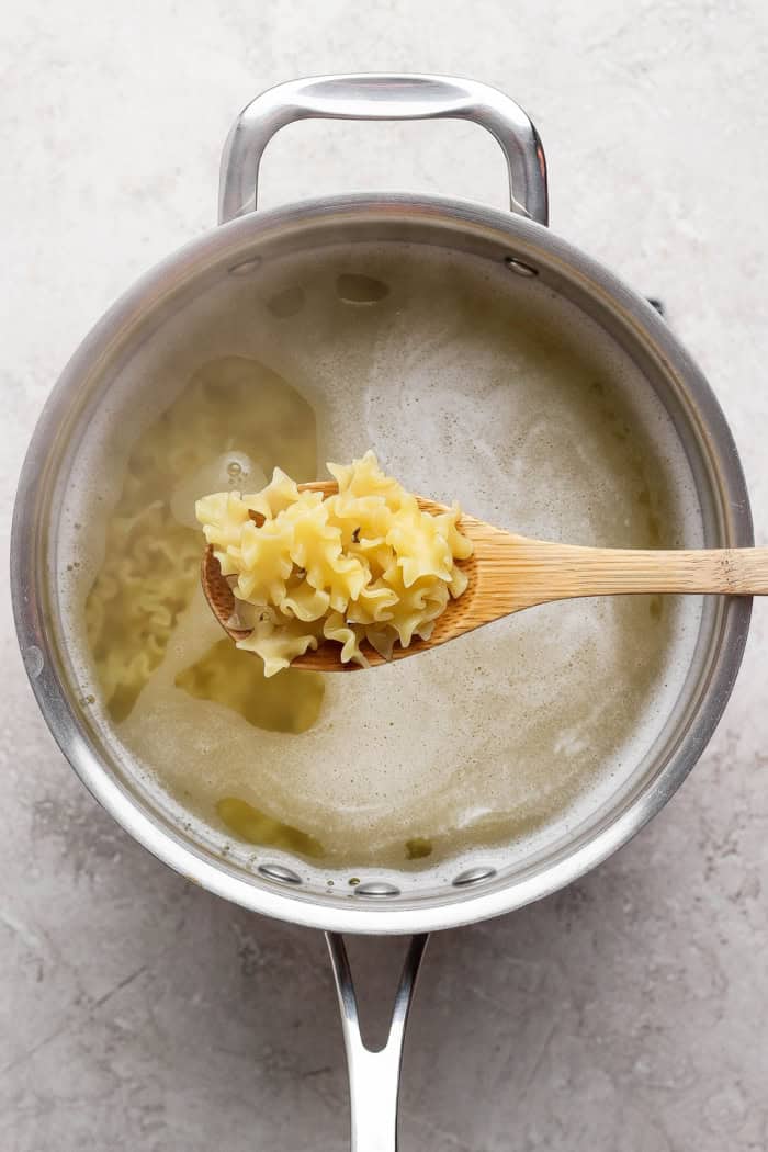 cooking mafalda pasta in a large stainless steel pot of hot water