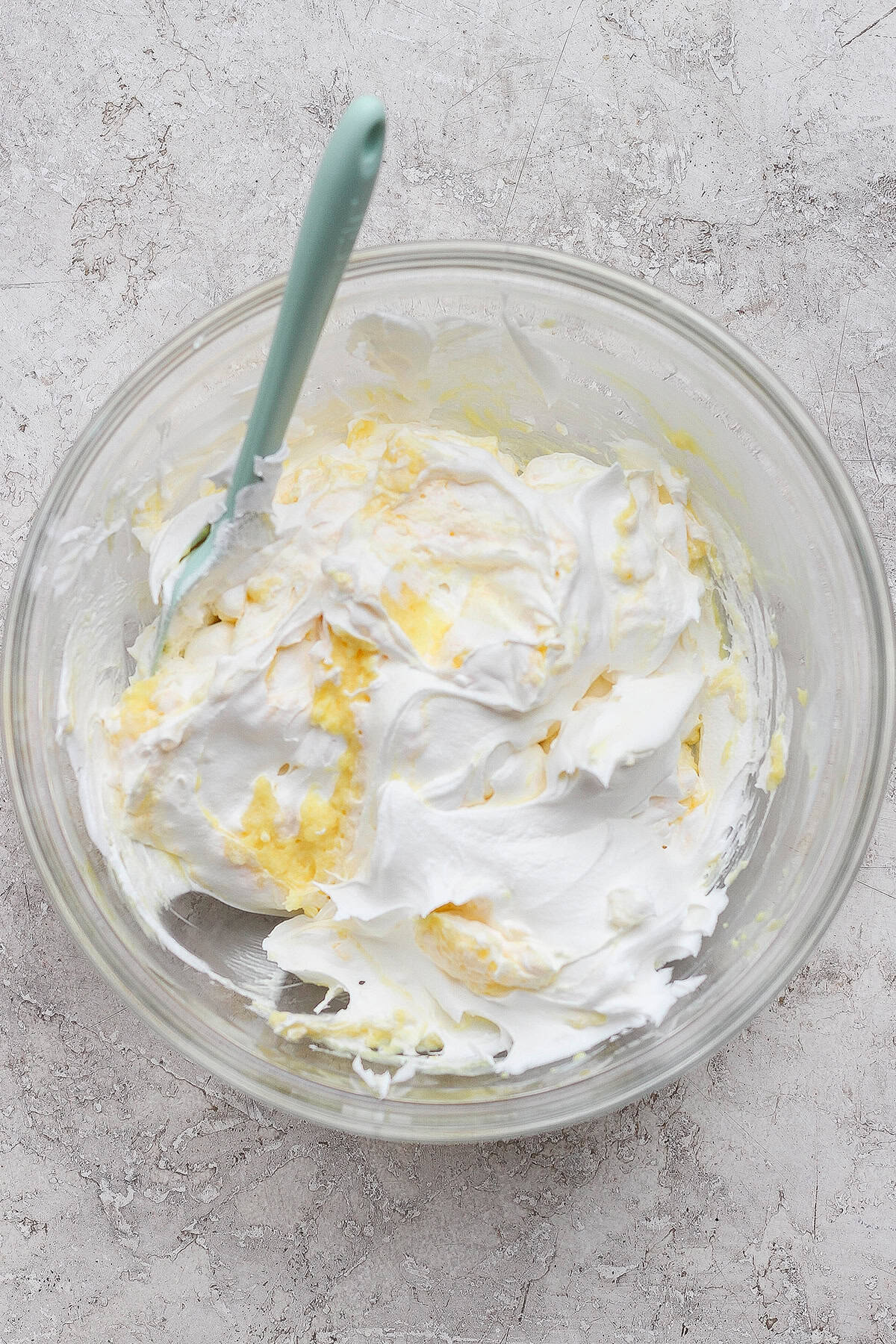 Folding Cool Whip into the mixture of buttermilk and vanilla pudding mix in a large clear bowl